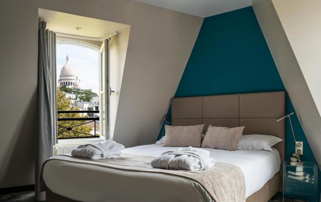 1 cama con toallas en una habitación con ventana en Timhotel Montmartre, en París