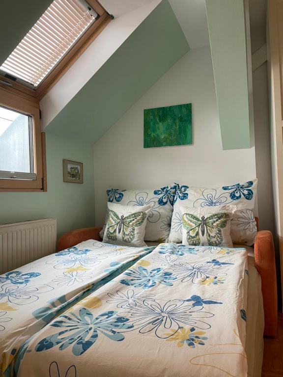 a bedroom with a bed with a blue and white comforter at Grazer Schwalbe in Graz
