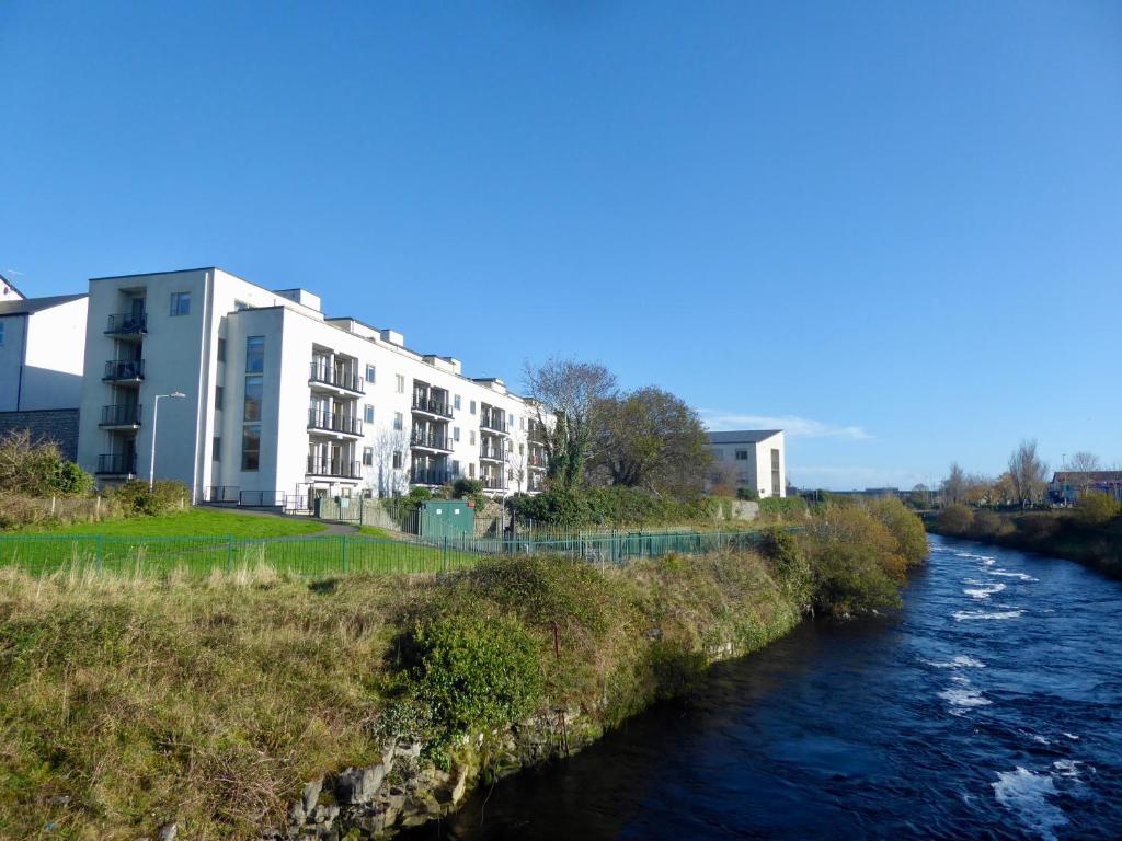 a building on the side of a river at Assaroe Falls in Ballyshannon