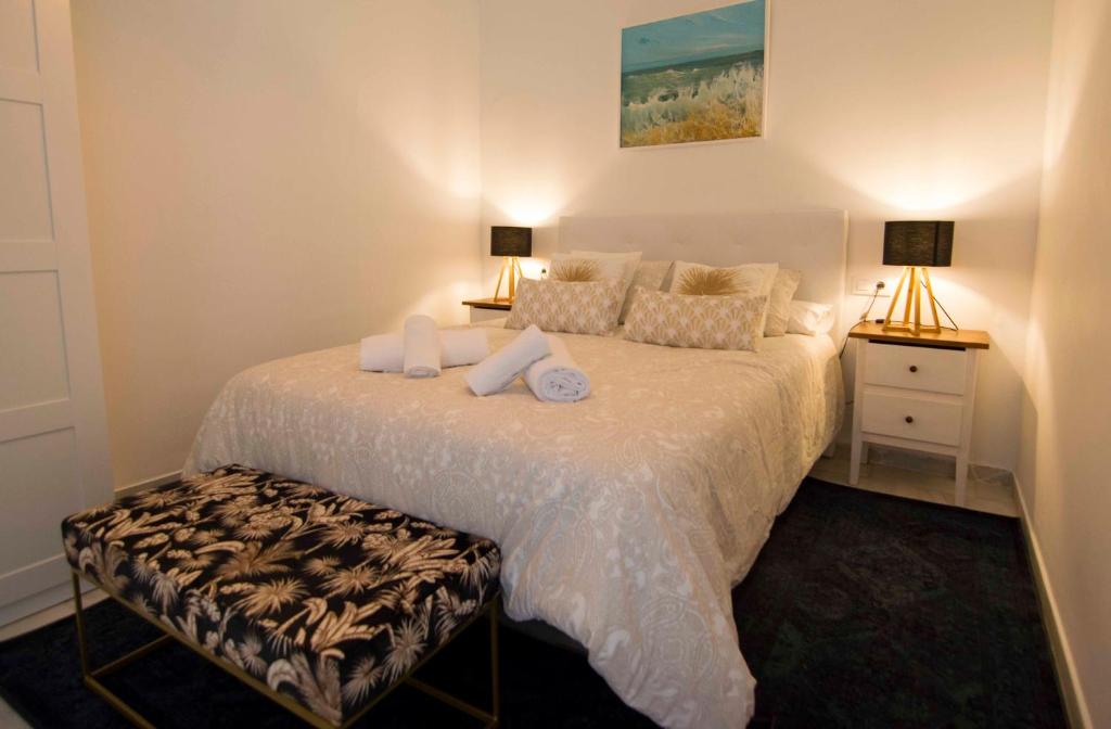 um quarto com uma grande cama branca e 2 candeeiros em El Sabor del Sur, Apartamentos Living Sur em Sanlúcar de Barrameda