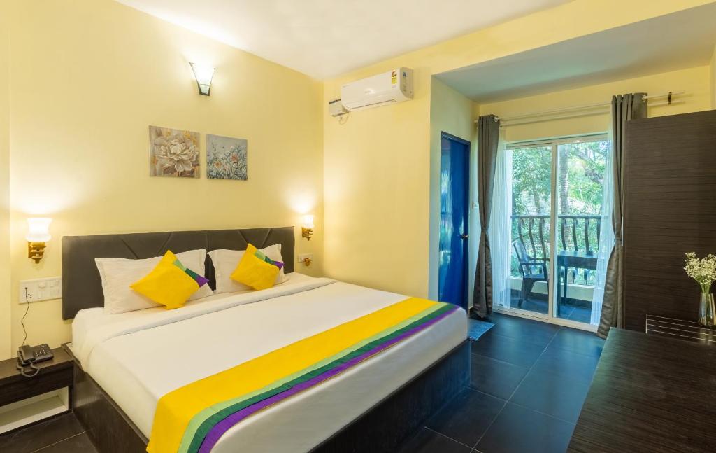 a bedroom with a large bed with yellow and colorful pillows at Blue Door in Morjim