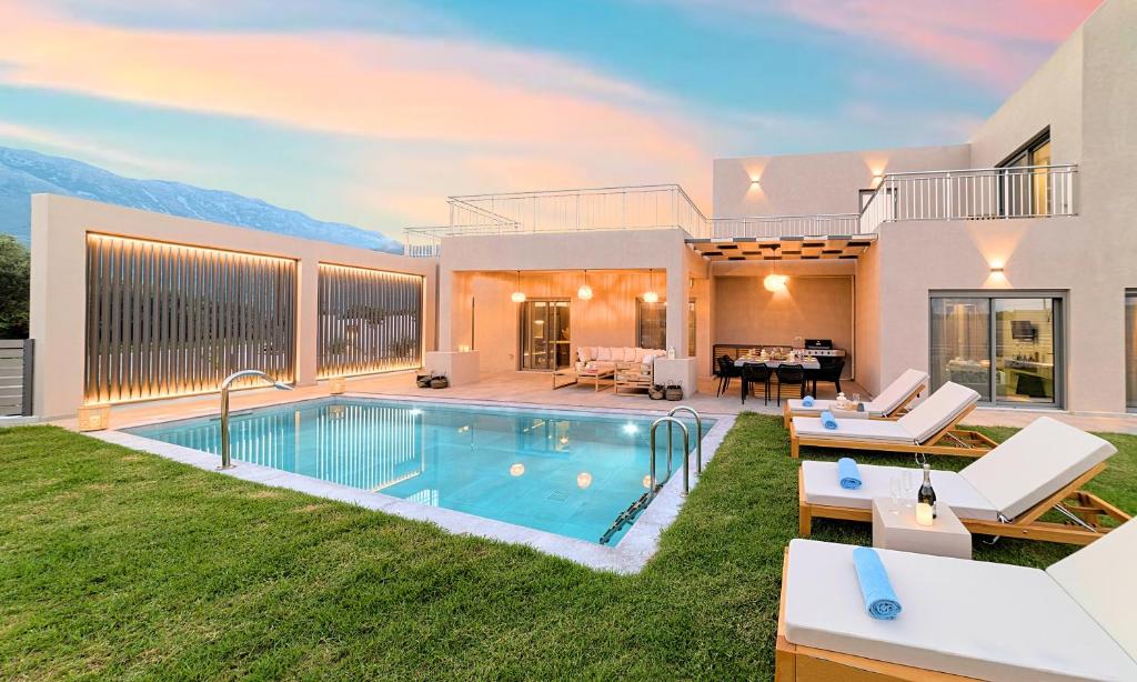 a house with a swimming pool and a backyard at KS Luxury Villas Heated Pools in Georgioupolis