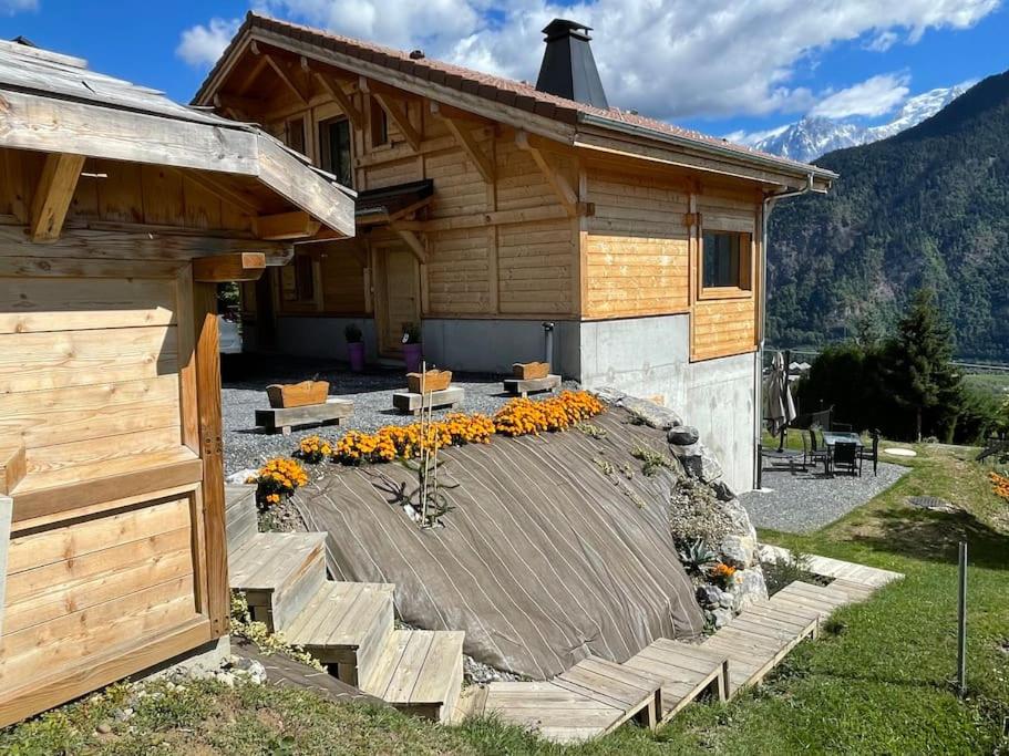 a house with a deck with flowers in front of it at Gîte Au Balcon de Passy/Plaine Joux, classé 2 ** in Passy