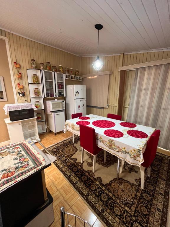 a kitchen with a table with red roses on it at Casa Estrela Guia in Urubici