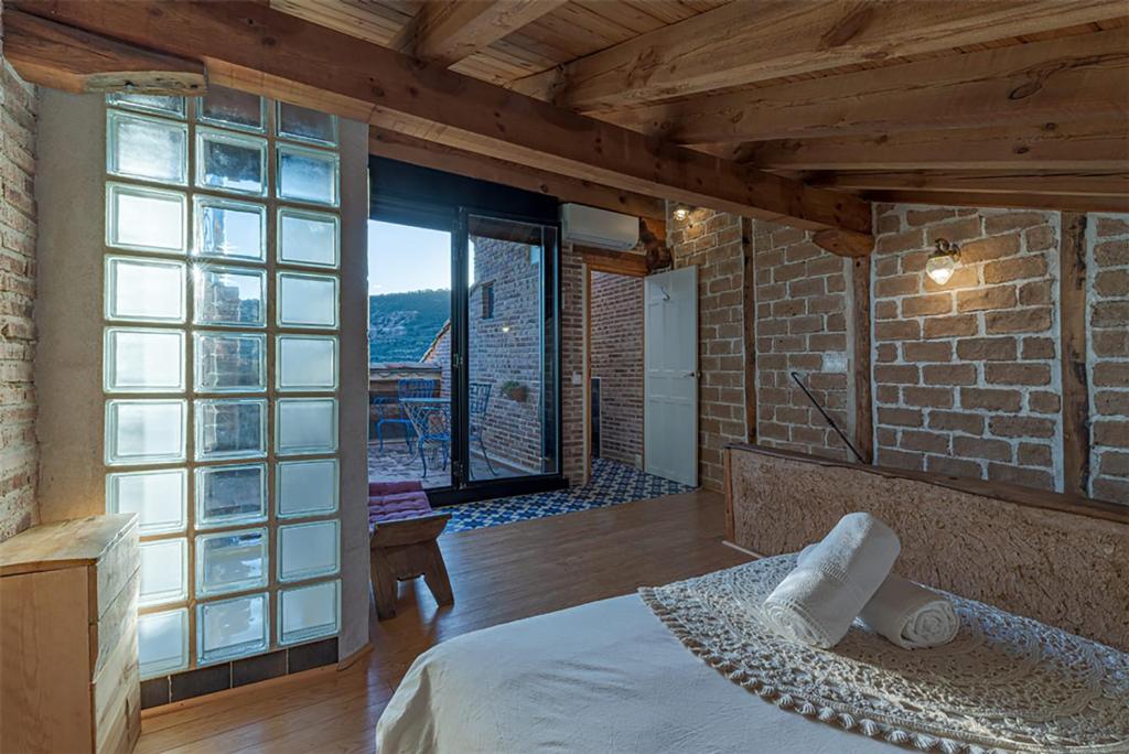 ein Schlafzimmer mit einem Bett und einem großen Fenster in der Unterkunft Casa la nuri in Utande