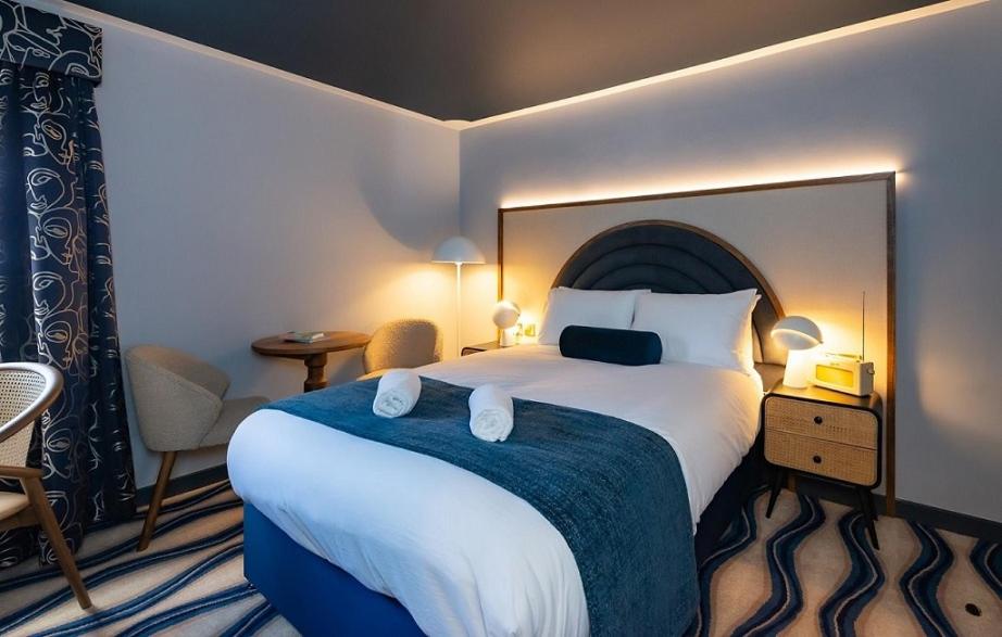 Habitación de hotel con cama grande con manta azul en The Anchorage, en Poole