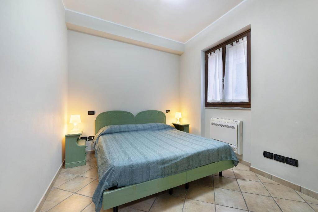Un dormitorio con una cama verde y una ventana en Ultimo Tiro - app Secondo Tiro en Cisano sul Neva