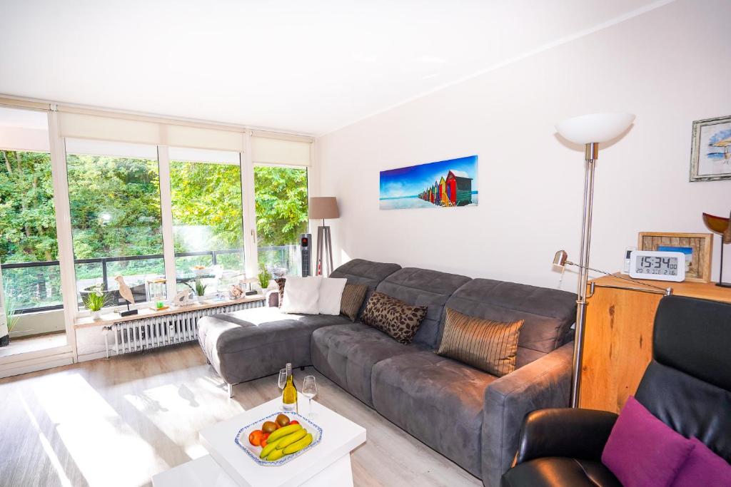 sala de estar con sofá y mesa en Fewo "Seglernest", mit Schwimmbad und Sauna, en Timmendorfer Strand