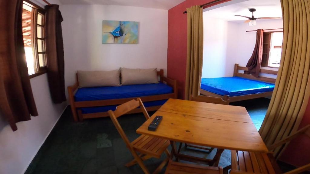 uma sala de estar com uma mesa e um sofá em Residencial Chalés Âncora em Ubatuba