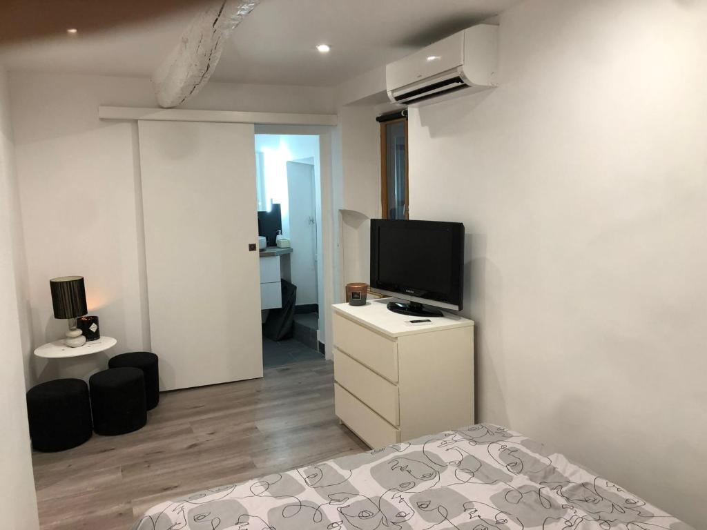une chambre avec un lit et une télévision sur une commode dans l'établissement Cœur de grasse, à Grasse