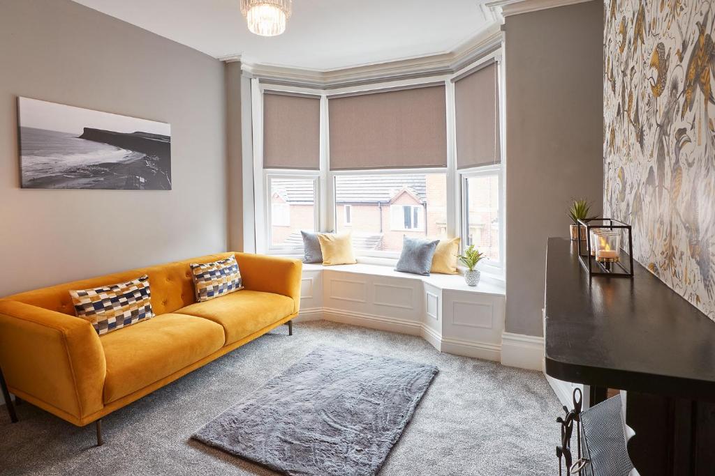 a living room with a couch and two windows at Host & Stay - Fly Away at Ruby in Saltburn-by-the-Sea