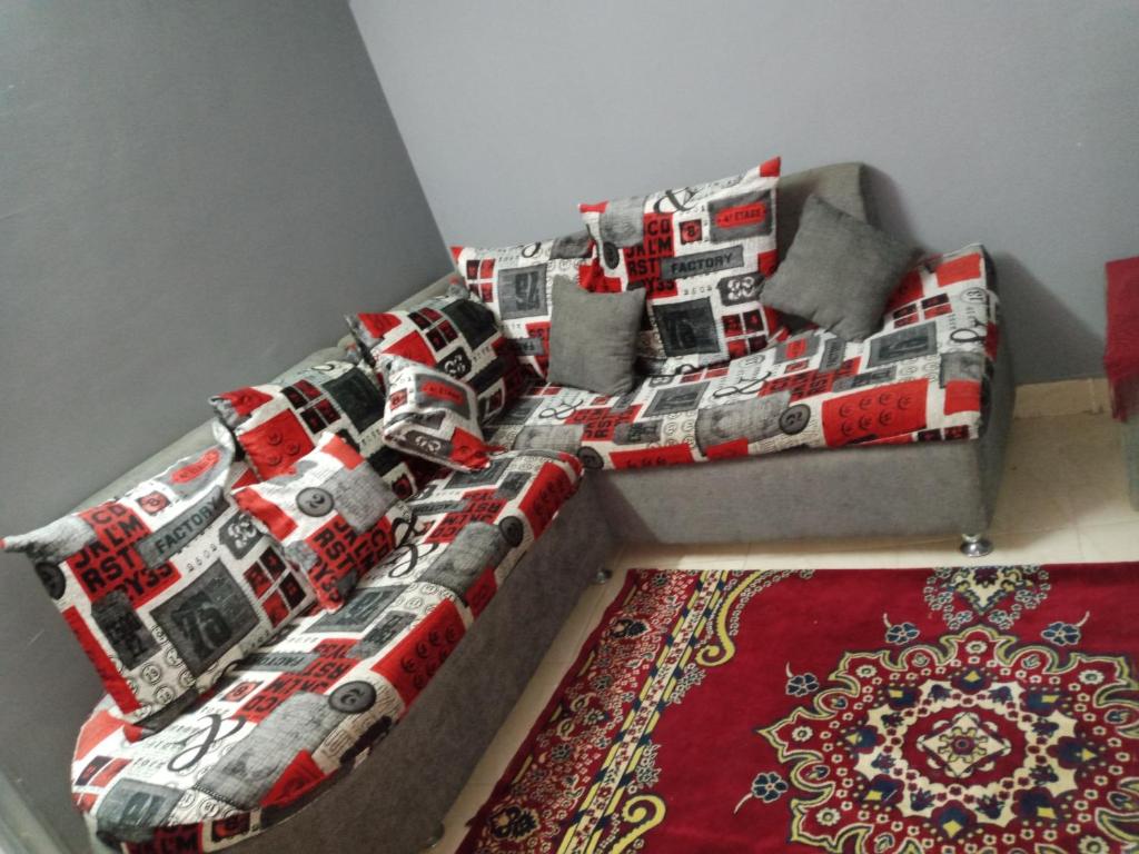 Fekry home في أسوان: سرير في غرفة مع أريكة وسجادة
