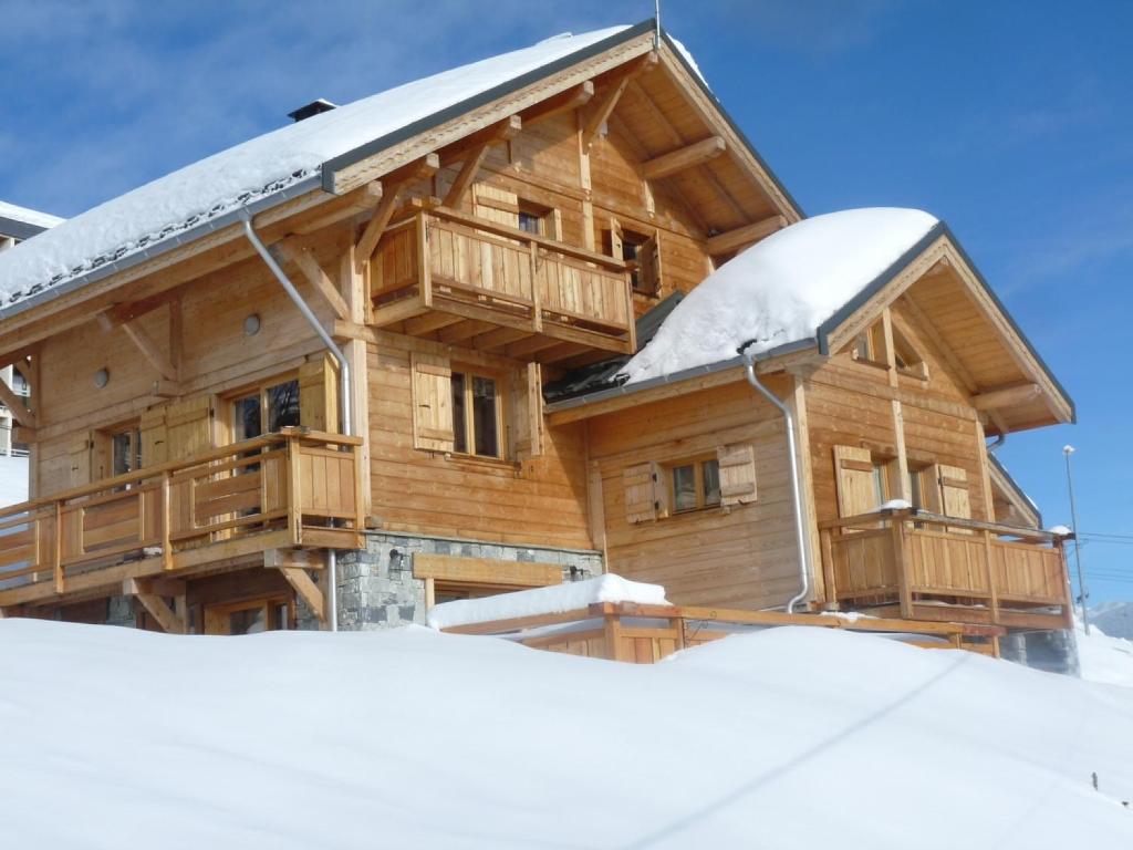 a log cabin in the snow with snow at Odalys Chalet Jardin d'Hiver in La Toussuire