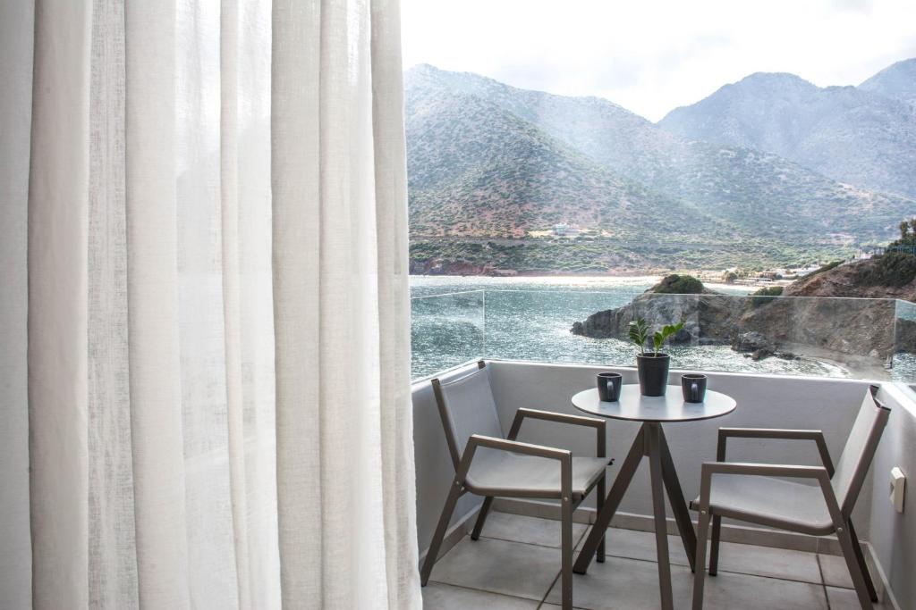 a table and chairs in a room with a view of the ocean at Bali Diamond "by Checkin" Adults Only in Bali