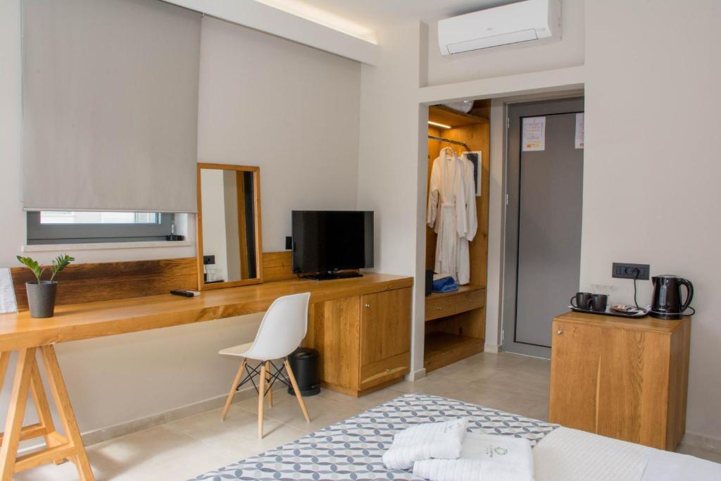 a room with a desk with a television and a chair at Bali Diamond "by Checkin" Adults Only in Bali