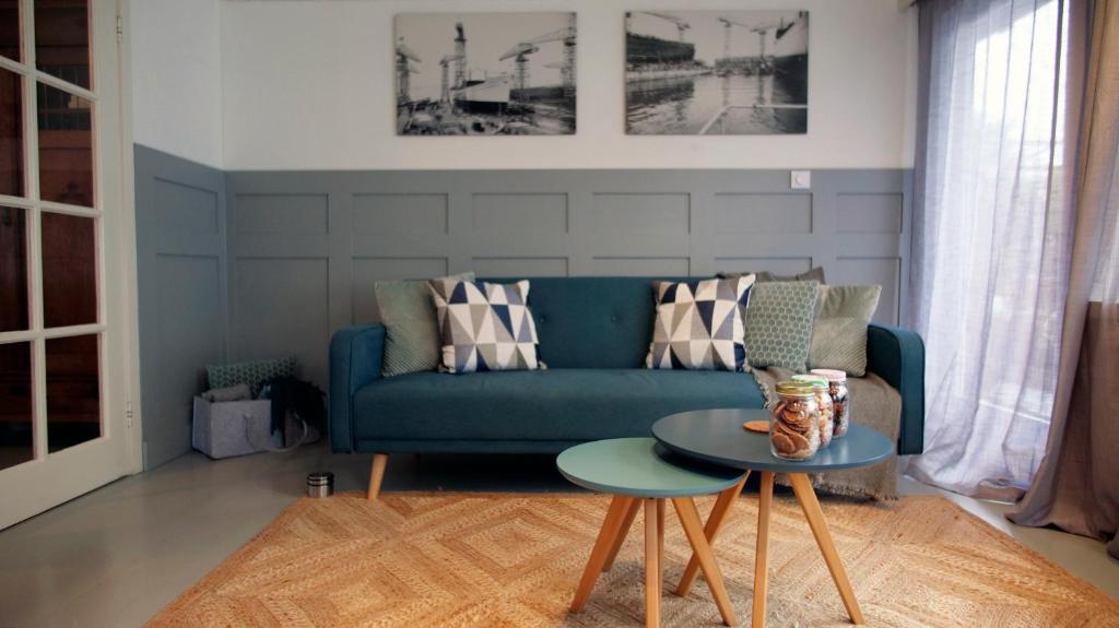 a living room with a blue couch and a table at Houseboat apartment with water terrace, free bikes & fast wifi in Amsterdam