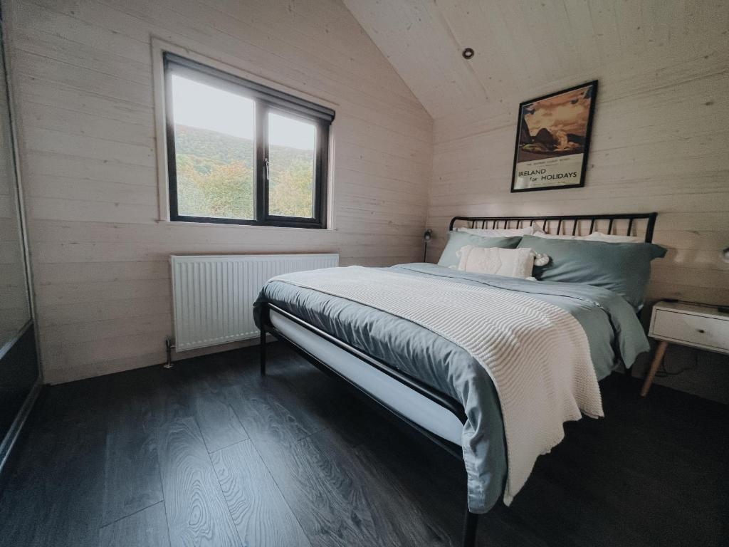 a bedroom with a bed and a window at Briarfield Farm Stays - A Unique Coastal Getaway in Glenarm