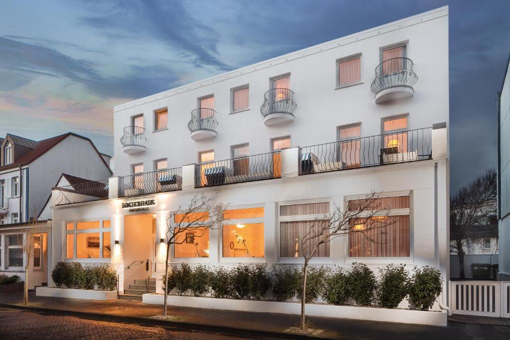 un edificio blanco con balcones en una calle en Logierhaus am Rathaus, en Norderney