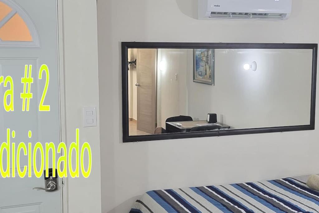 a mirror on the wall of a bedroom with a bed at Departamento Privado7, 2 camas matri, parking, cocina equipada, wifi 65 mb, 2 Climas,Centrico,Tv smart in Ciudad Valles