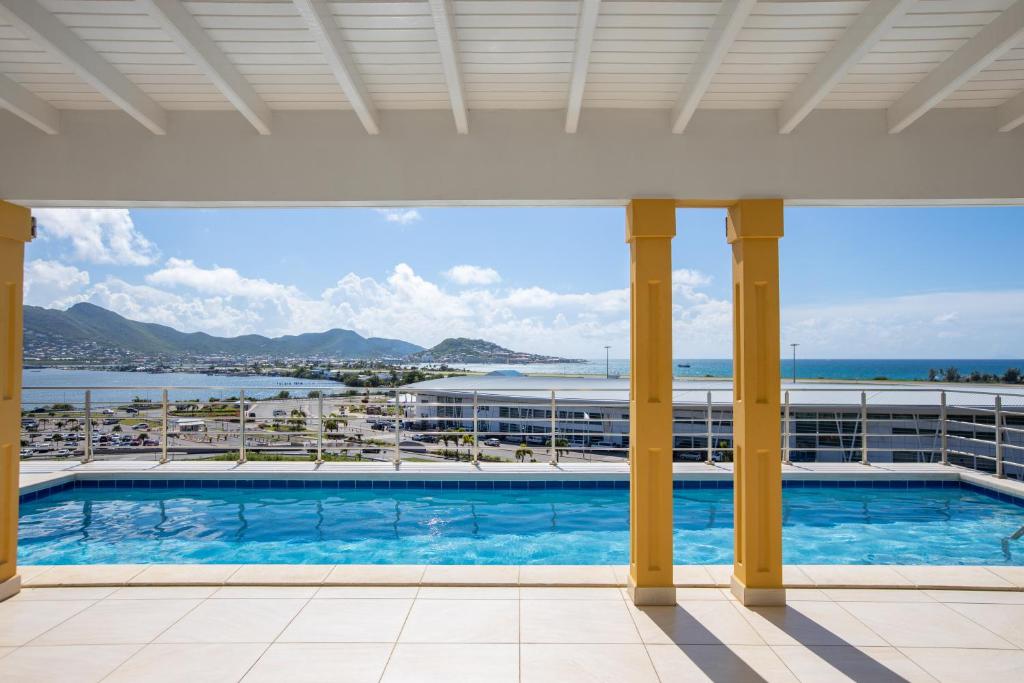 vistas a la piscina desde el balcón de un hotel en Reflection Y 5 Star Villa, en Maho Reef