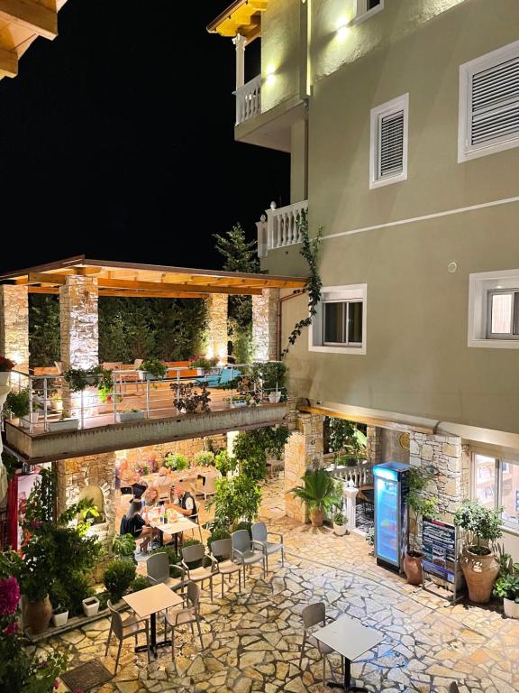 a hotel patio with tables and chairs at night at Vila Arial in Vlorë