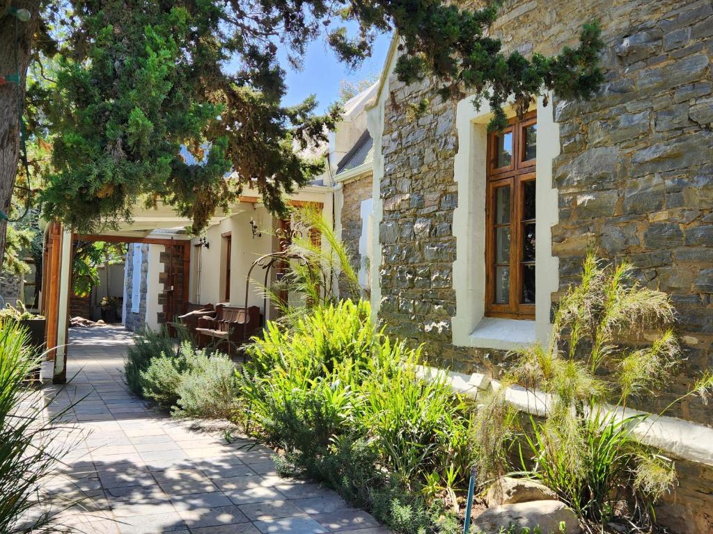 a stone house with a pathway leading to the front yard at St Aidan's Manor in Grahamstown