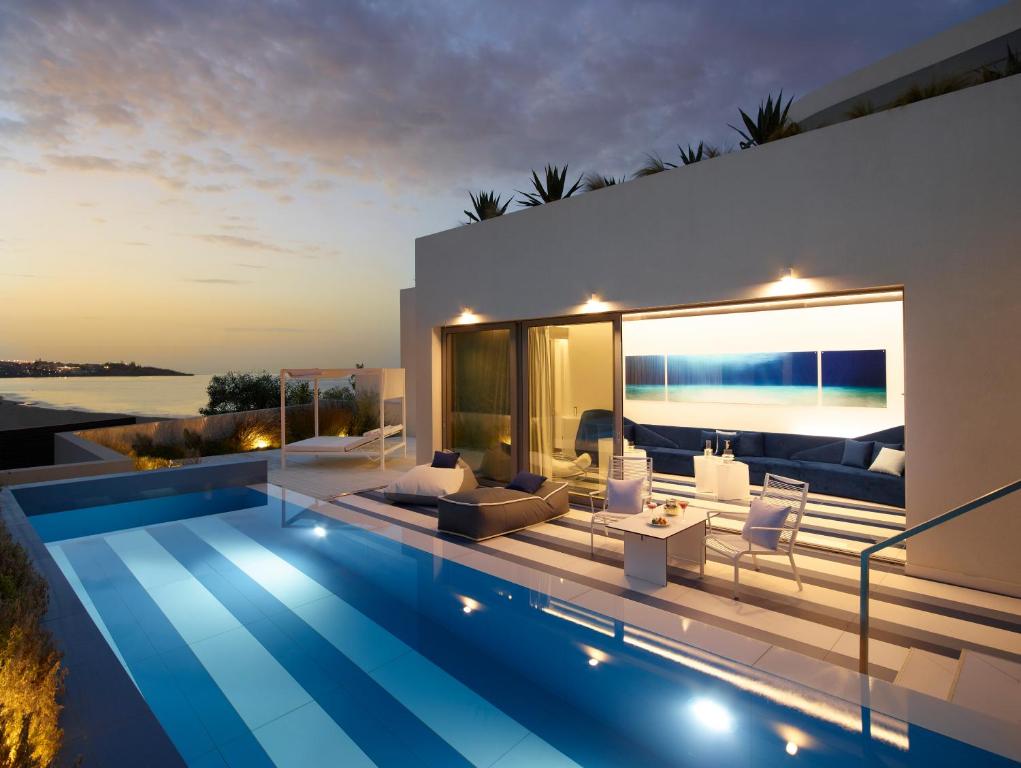 Villa con piscina al atardecer en I Resort Beach Hotel & Spa en Stalida
