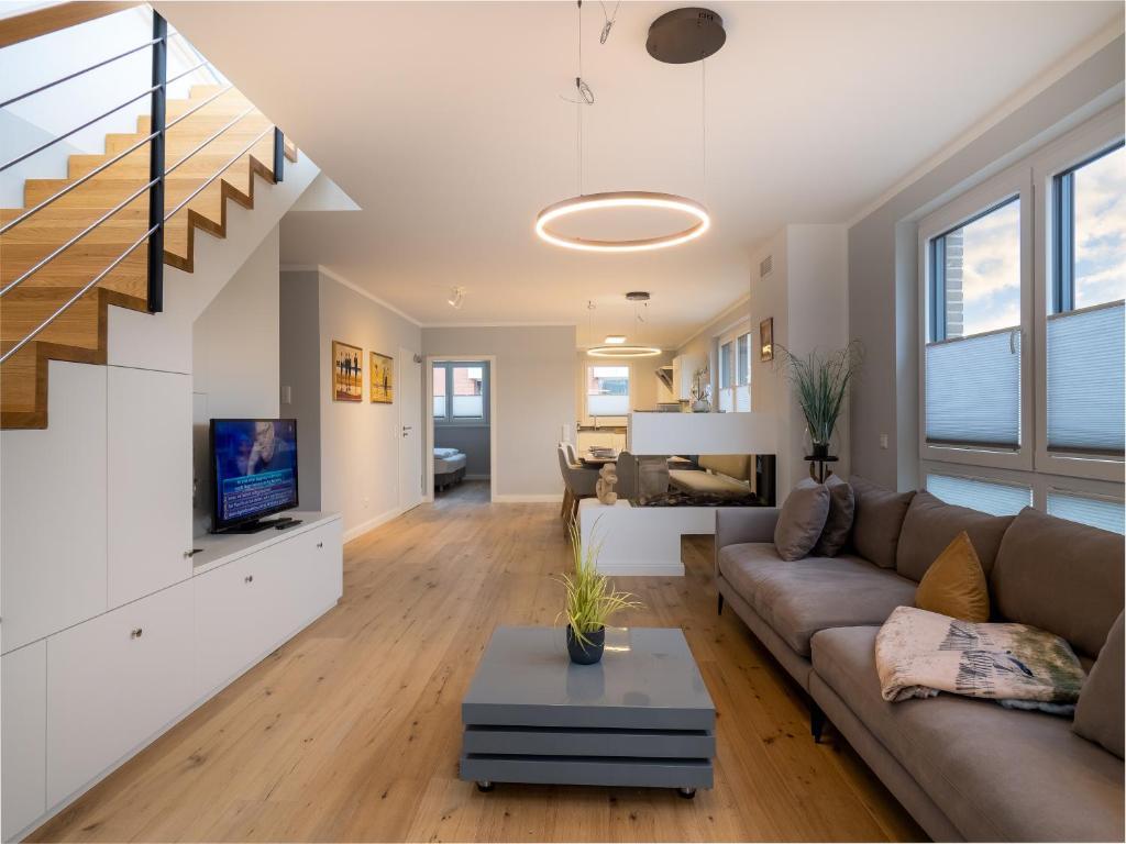 a living room with a couch and a tv at Strandgutresidenz in Westerland (Sylt)