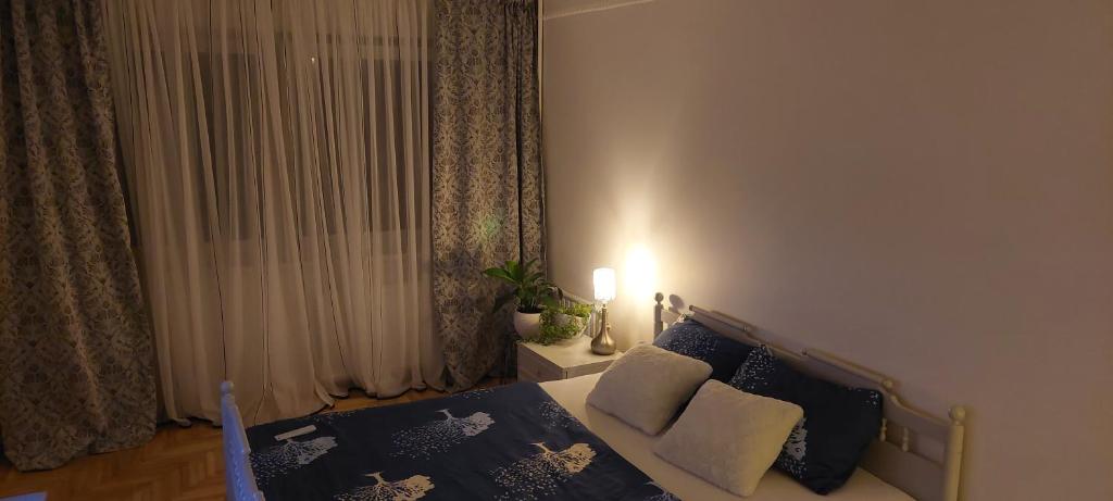 um quarto com uma cama com almofadas azuis e brancas em Pakeliui em Kaunas