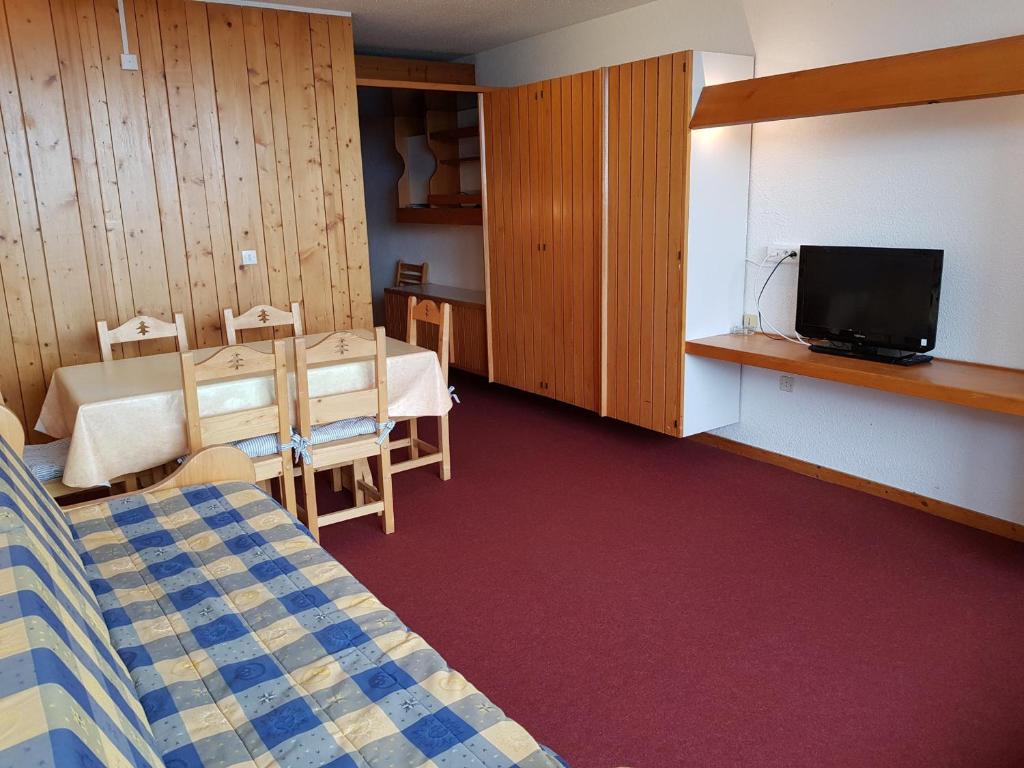 Cette chambre comprend un lit, une télévision et une table. dans l'établissement Appartement Les Arcs 1600, 2 pièces, 6 personnes - FR-1-411-340, à Arc 1600