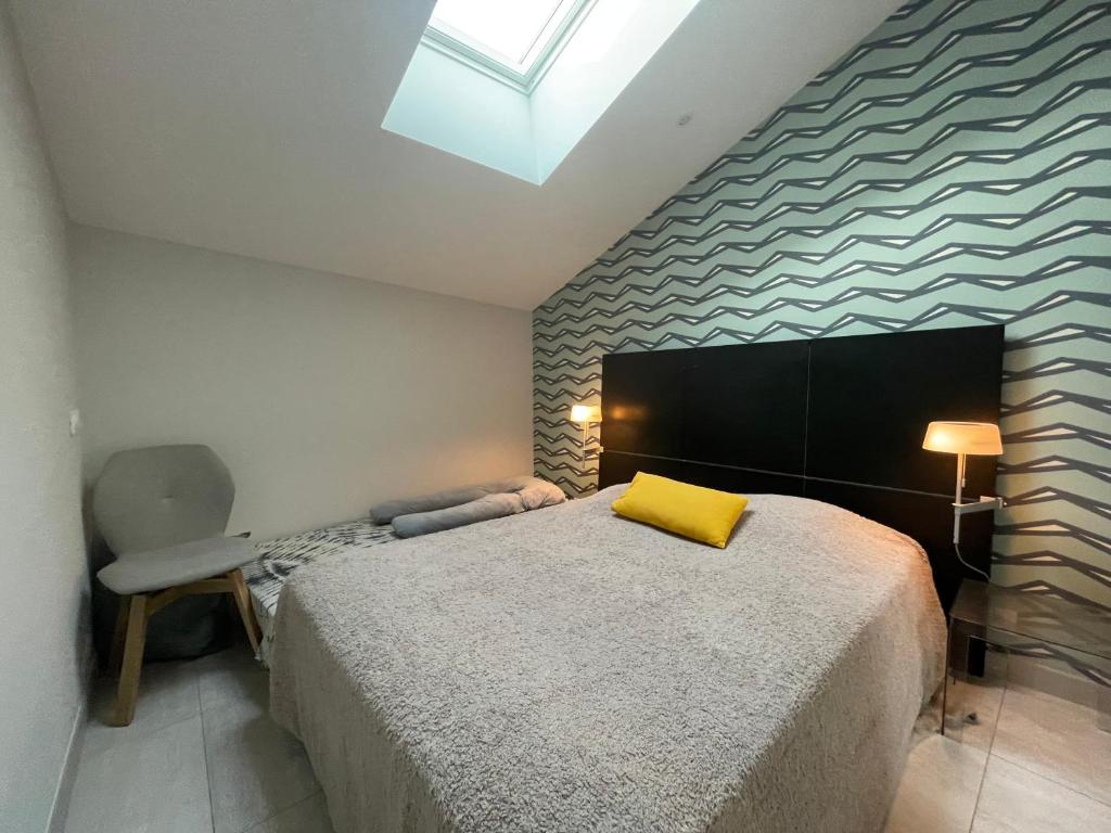 una camera da letto con un letto con un cuscino giallo di Villa des Huniers à La Chaume a La Chaume