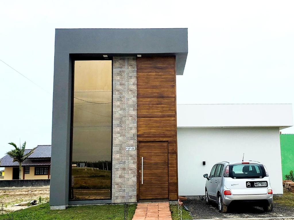a car parked in front of a house with a door at BALNEÁRIO GAIVOTA no AREIAS CLARAS in Sombrio