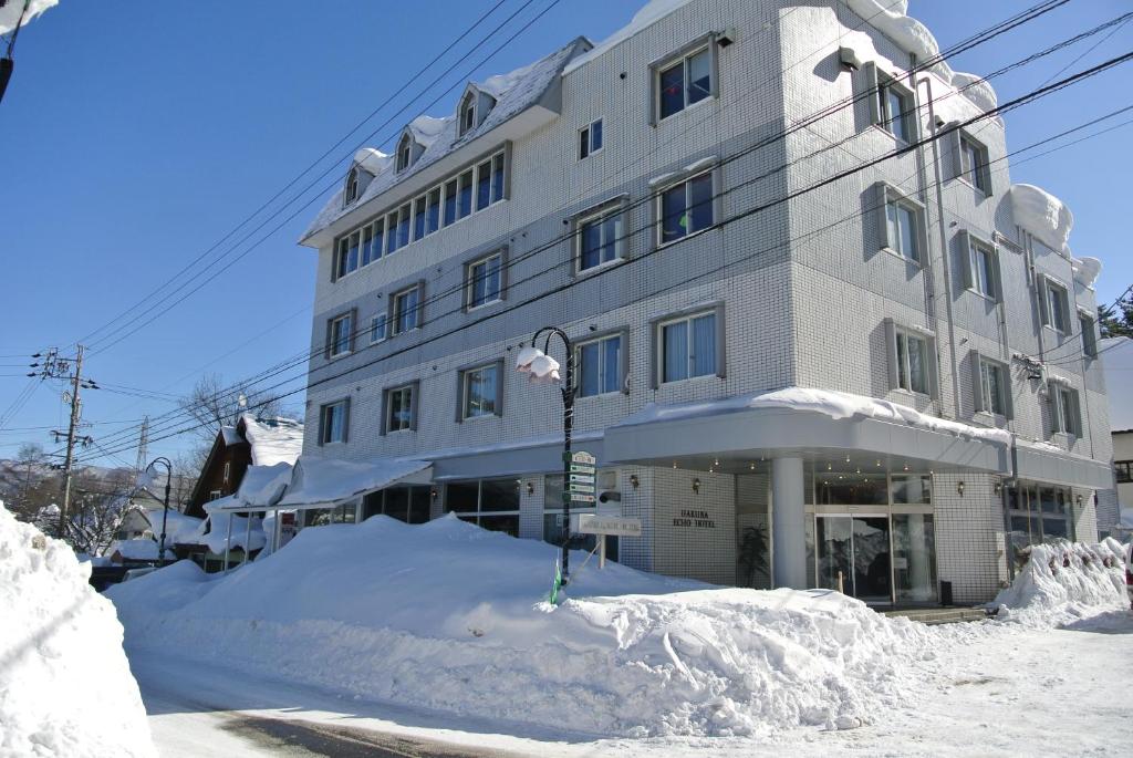 a building with a pile of snow in front of it at Hakuba Echo Hotel and Apartments in Hakuba