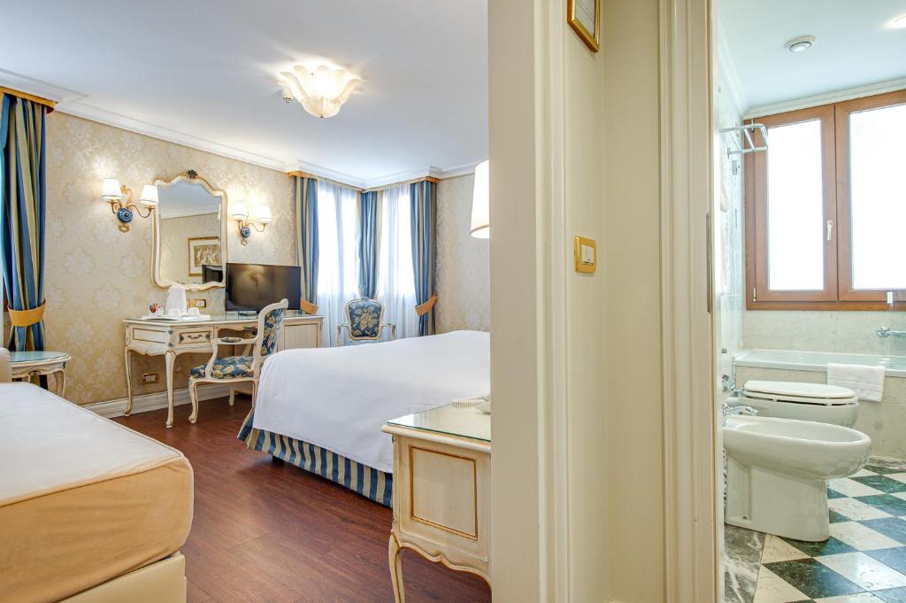 a hotel room with a bed and a bathroom at Hotel Antiche Figure in Venice