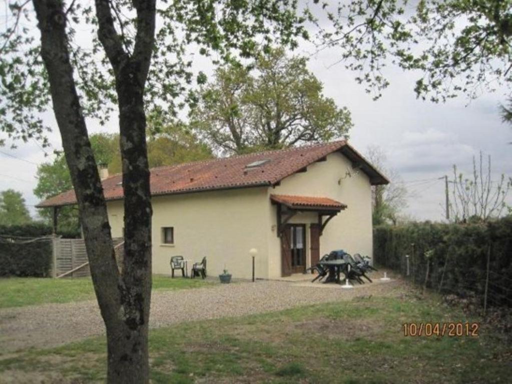 un pequeño edificio blanco con una mesa delante en Les Chênes 2 - cadre verdoyant en Eugénie-les-Bains