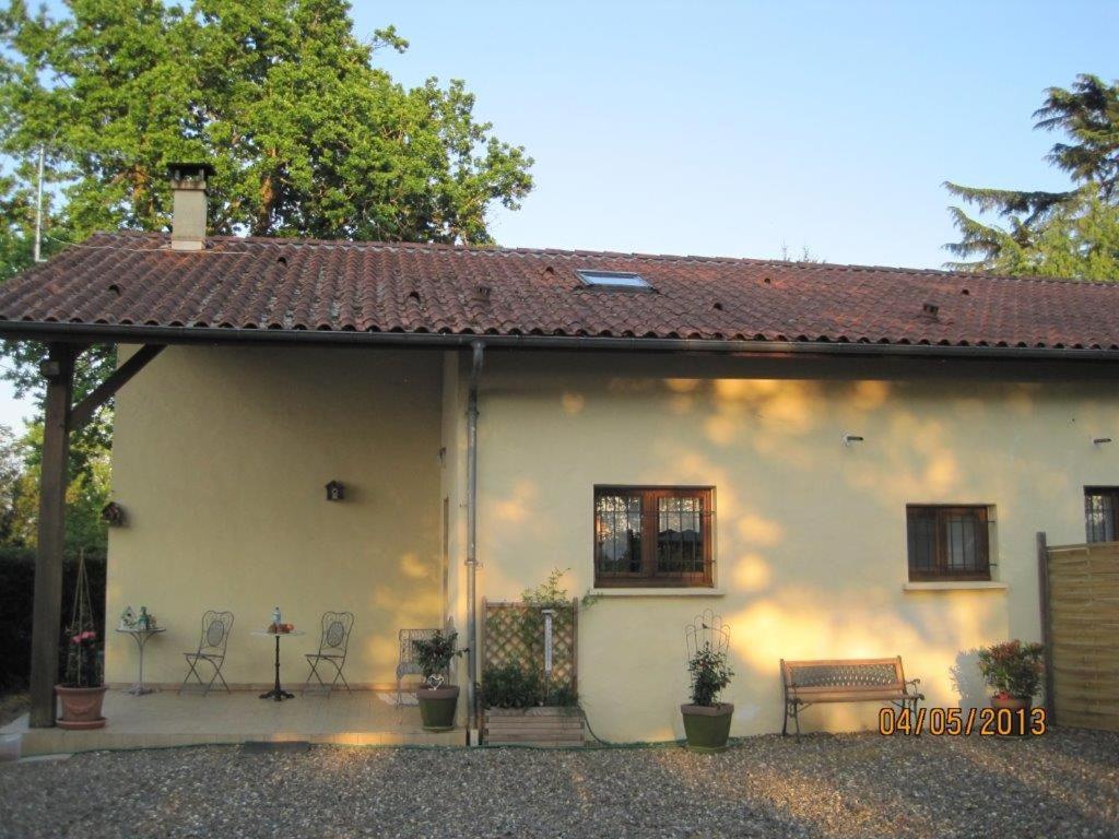 a white house with a red roof and two chairs at Les Chênes 2 - cadre verdoyant in Eugénie-les-Bains