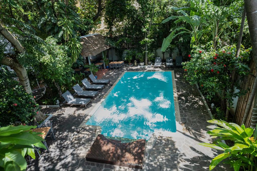 a swimming pool with two lounge chairs and a swimming pool at Jungle Addition in Phnom Penh