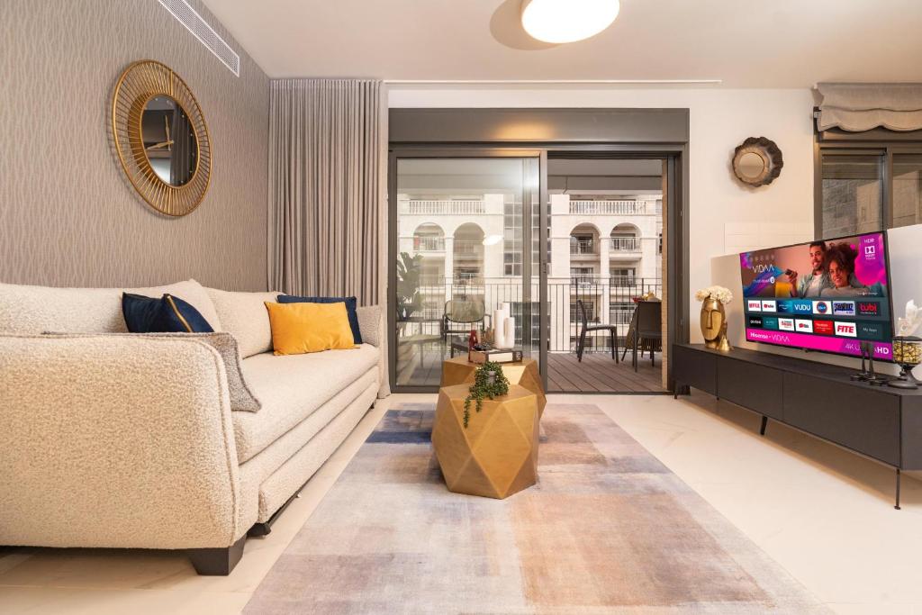 a living room with a couch and a tv at Central and Luxury New 2BR&2Bth - Private Parking in Jerusalem