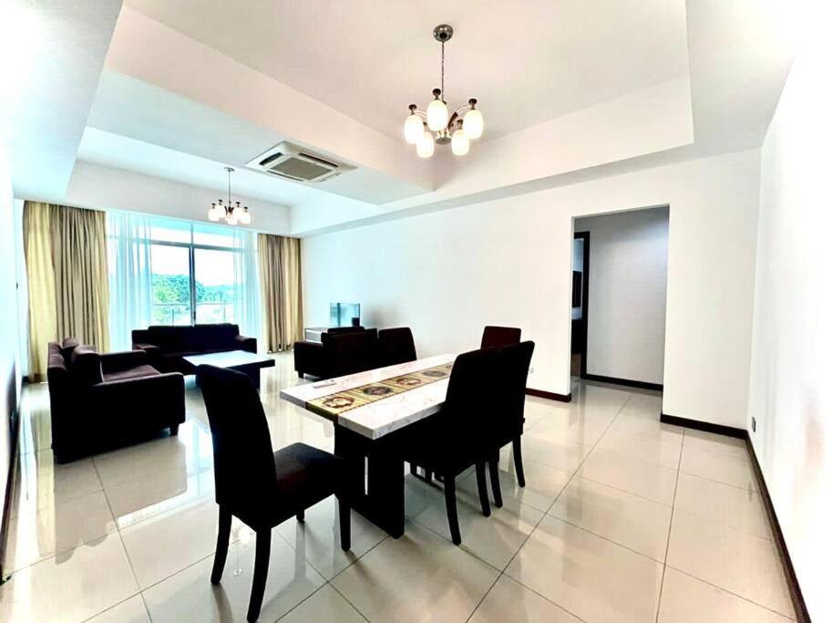 een eetkamer en een woonkamer met een tafel en stoelen bij Bay Resort Condominium 3-bedrooms with Swimming Pool near the Seaside in Miri