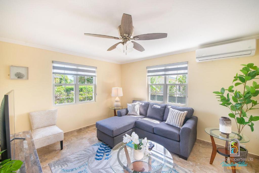 a living room with a couch and a ceiling fan at Dover Court Apartments - Steps to St Lawrence Gap in Christ Church