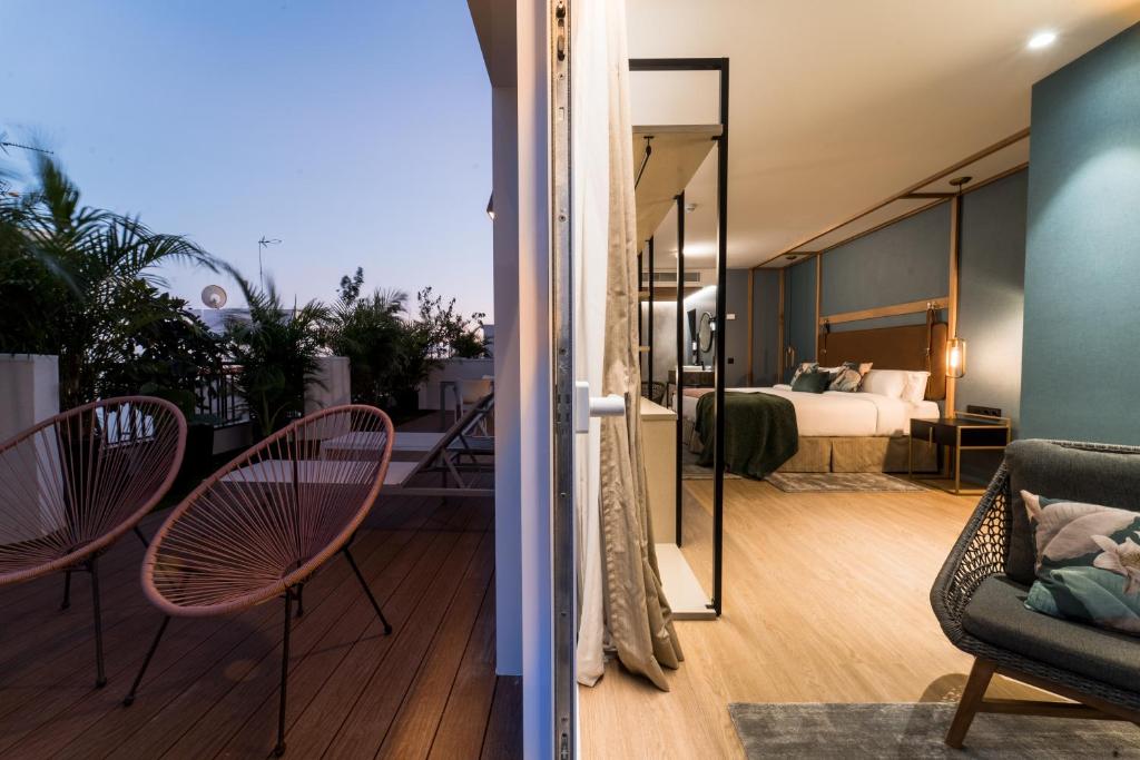 a room with a balcony with a bed and a bedroom at Hotel Taburiente S.C.Tenerife in Santa Cruz de Tenerife