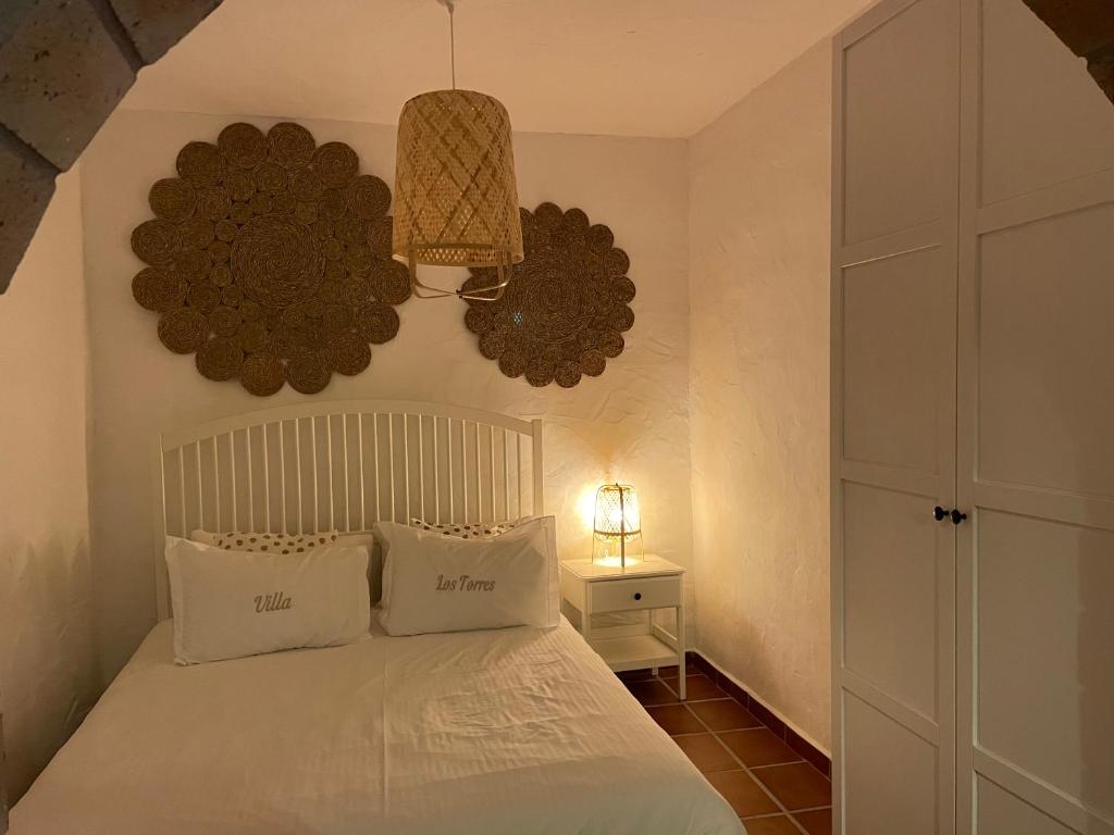 1 dormitorio con 1 cama blanca y 2 almohadas en Los Torres II, en Fuencaliente de la Palma