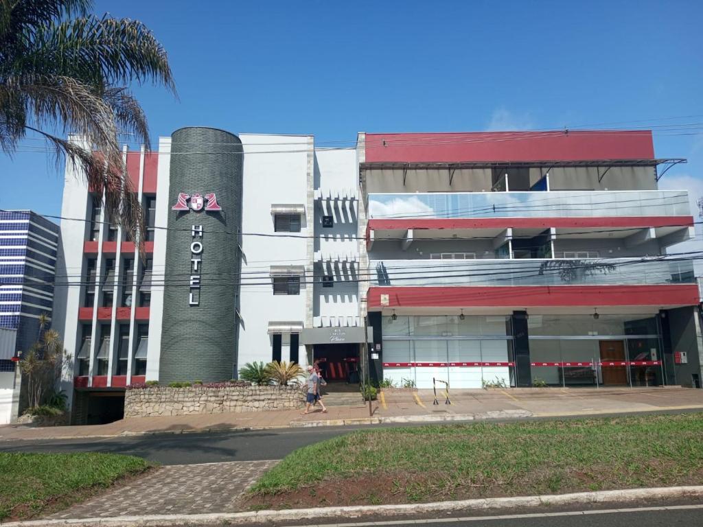 a building with a clock tower in front of it at Carlton Plaza Torre in Araxá