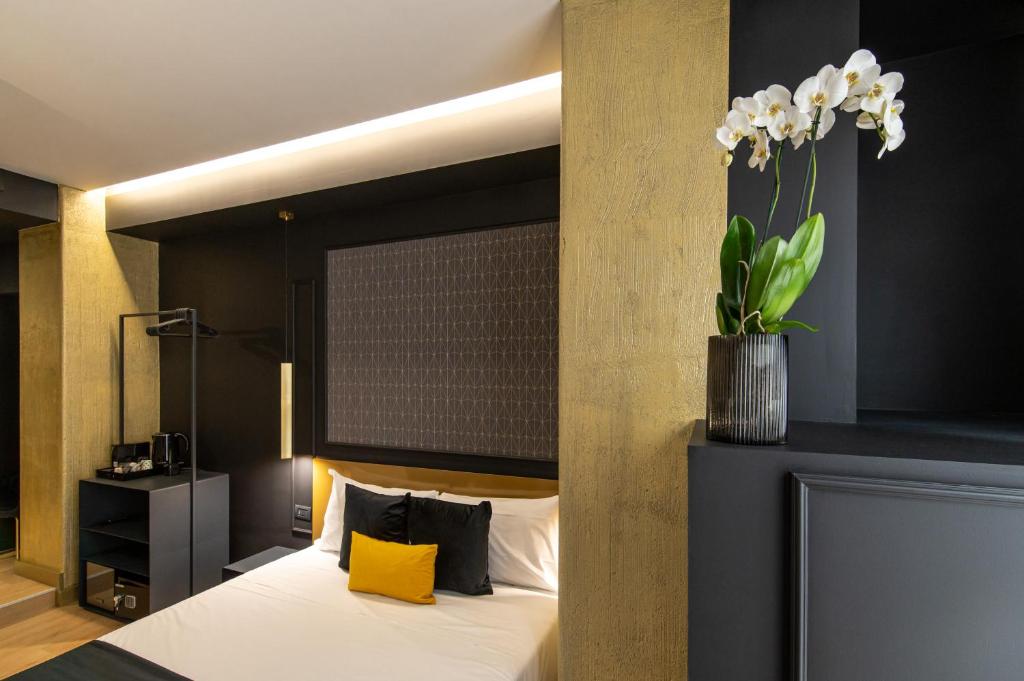 ナポリにあるPlebiscito Boutique Roomsの花瓶が飾られたベッド付きのベッドルーム1室
