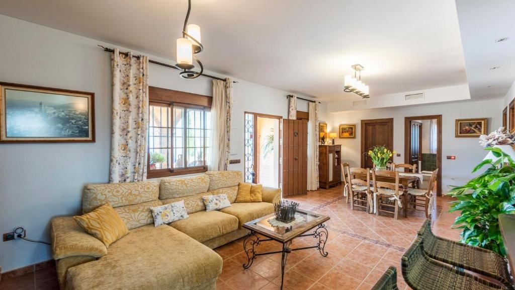 a living room with a couch and a table at Casa Cuatro Vientos Almogía by Ruralidays in Almogía