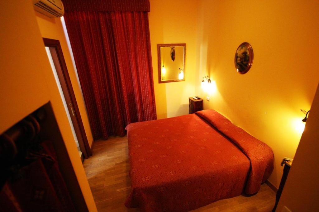 1 dormitorio con 1 cama naranja en una habitación en Hotel Termini, en Roma