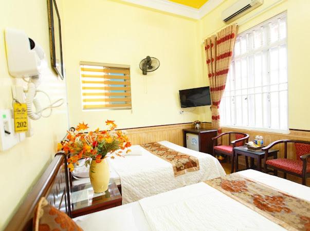 pokój hotelowy z 2 łóżkami i telewizorem w obiekcie Lam Dat Hotel w mieście Ninh Binh