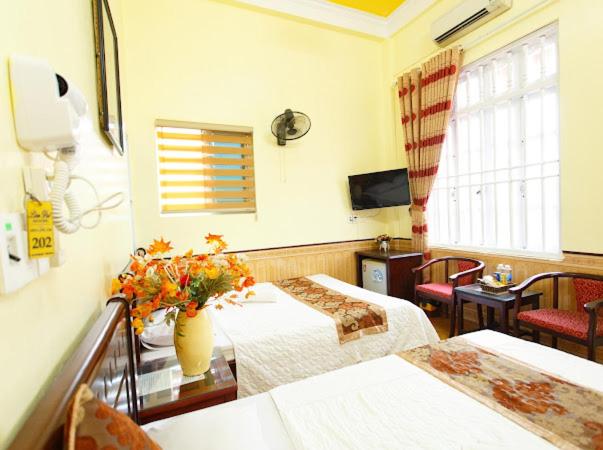 a hotel room with two beds and a television at Lam Dat Hotel in Ninh Binh