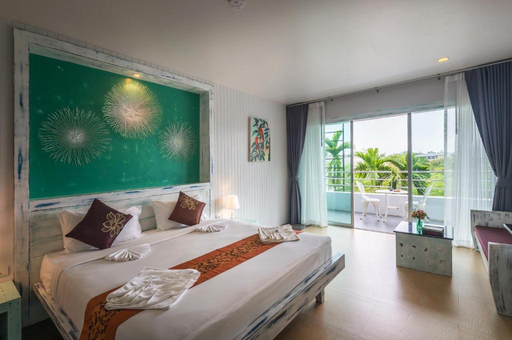 um quarto com uma cama grande e uma janela grande em Baan Ban Dalay em Praia de Aonang