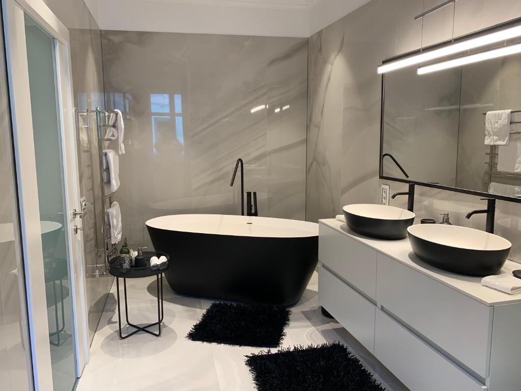 a bathroom with two sinks and a bath tub at Schillerplatz Apartment in Sibiu